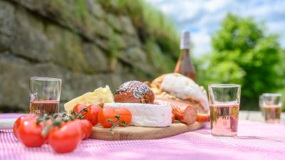 Bauernvesper mit Käse, Wurst, Tomaten, Weingläser und Weinflasche