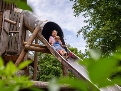 zwei Kinder auf einer Röhrenrutsche