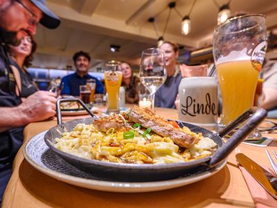 Menschen sitzen an einem Tisch mit Essen und Getränken