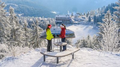 zwei Schneeschuhewanderer am Aussichtspunkt Mummelsee mit Wiinterladnschaft