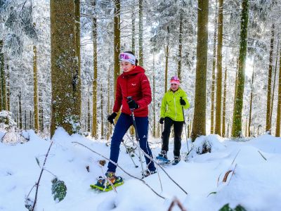 Zwei Menschen die eine Winterwanderung machen, mit Schneeschuhen